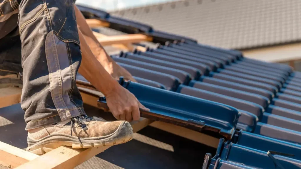 Roofer working on ceramic tile on the roof